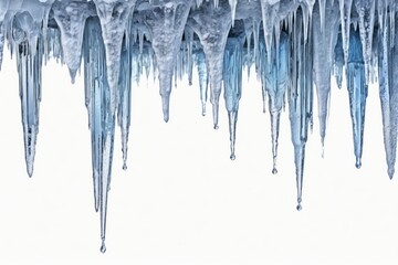 Icicles hanging against a white background with frost and melting water droplets in a winter scene
