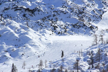 People having ski time in ski resort on a cold winter sunny day.