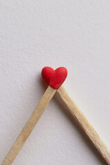Perfect match, close up of a couple of matchsticks forming heart shape on white background, love...