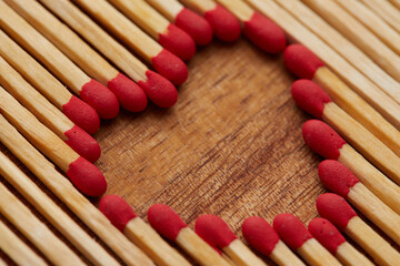 Close-up of heart made of match sticks on wooden background - Love concept