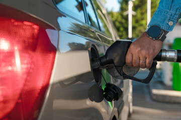 Filling up a car with gasoline at a fuel station during daylight hours