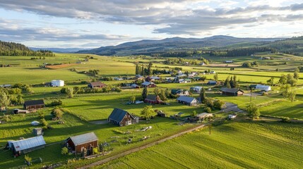 Naklejka premium A small rural community with houses spread out across green fields, with farms and barns in the distance.