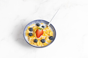 cornflakes  in a bowl on a light background, breakfast