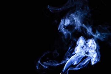 Smoke swirls creating abstract shapes on a dark background at night