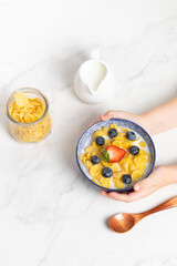 cornflakes  in a bowl on a light background, breakfast