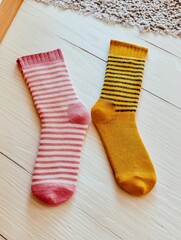 A pair of mismatched socks on a clean white floor, symbolizing imperfection and humor