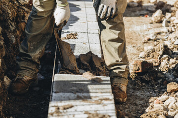 Construction worker laying concrete blocks in a residential area 