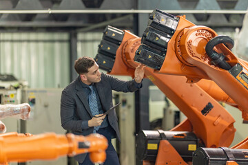 Factory Owner and Manager Inspecting Robotic Arm