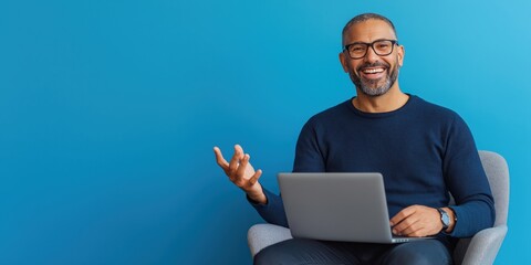 A man with a laptop on his lap and gesturing positively about a successful outcome