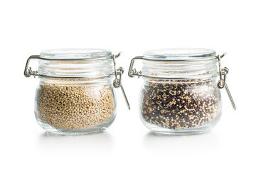 Mixed and white uncooked quinoa seeds in jars isolated on white background.
