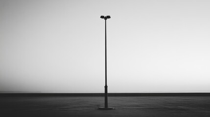 Tall light pole in monochrome, minimalist setting.