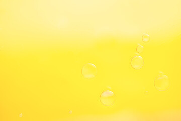 Beautiful cosmetic background. yellow abstract oil bubbles or face serum background. Copy space