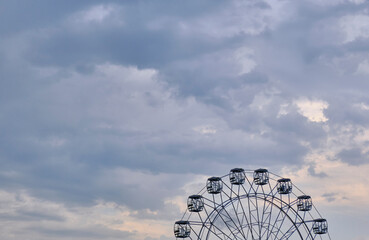 Ferris wheel against cloudy sky