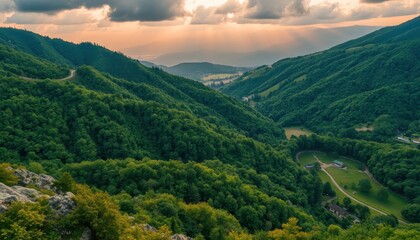 Fototapeta premium Sunset Over Lush Green Mountain Valley Landscape
