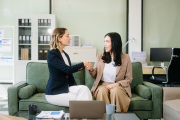 Two businesswomen collaborate using a tablet in a stylish office setting. Perfect for concepts