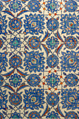 A close up of traditional Ottoman Iznik tiles featuring floral and geometric patterns in blue, red and white. This historical ceramic art reflects rich Turkish heritage