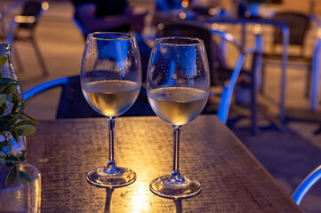 Two glasses of cold dry white wine served outdoor in cafe at night in historical Triana district, Sevilla, Spain, close up