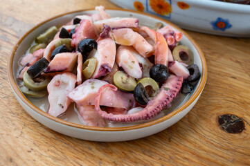 Tasty salad or starter seafood dish, grilled octopus ligurian style with green and black olives served in Italian  restaurant