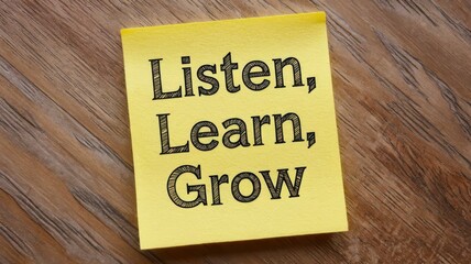 Handwritten reminder on sticky note: "Listen, learn, grow" for personal growth