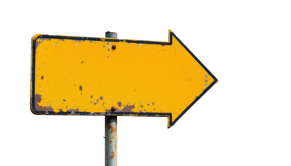 Vintage yellow directional arrow sign with black trim on a black background