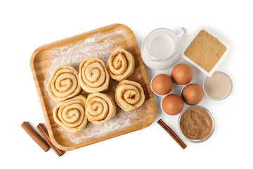 Raw cinnamon rolls and different ingredients isolated on white, top view
