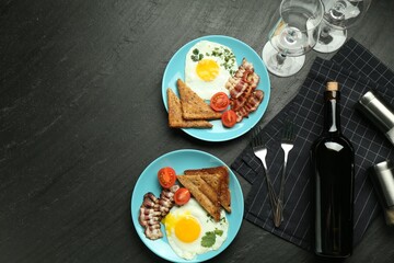 Tasty food and wine served for brunch on black table, flat lay. Space for text