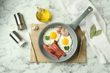 Tasty brunch. Fried eggs, sausages and bacon served on white marble table, flat lay