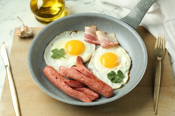 Tasty brunch. Fried eggs, sausages and bacon served on white marble table, closeup