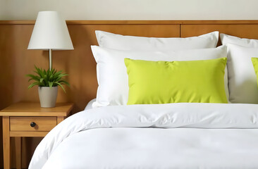 Green Pillow Accents Modern Bedroom Scene. A lime green pillow accents a bed with white sheets and pillows and a wooden headboard. 