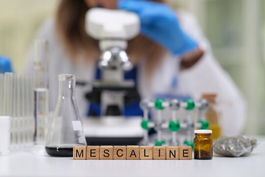A researcher examines mescaline samples in a laboratory environment, emphasizing scientific analysis.