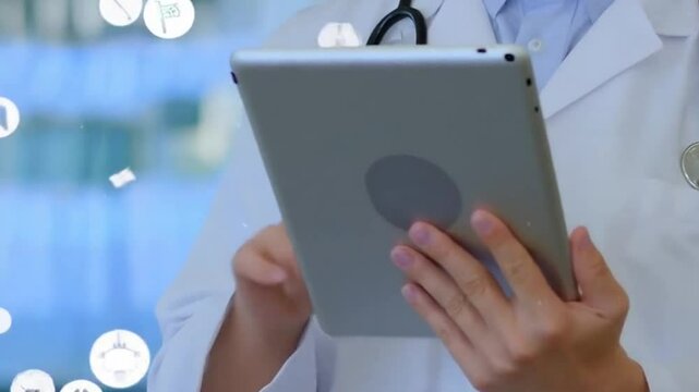  Doctor usando una tableta, con &iacute;conos m&eacute;dicos volando alrededor