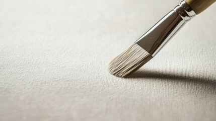 Close-up of a blank canvas with a paintbrush resting on it, ready for a creative masterpiece.