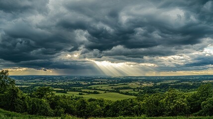 Dramatic storm clouds rolling in over a landscape, with rays of sunlight breaking through