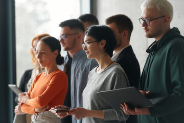 Fototapeta premium A group of accomplished business professionals stands together in an office, exuding unity, confidence, and a shared commitment to success and innovation.