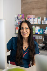 Veterinarian smiling while working on a computer at her desk in a veterinary clinic