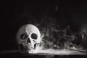 Human skull on a black background in smoke.