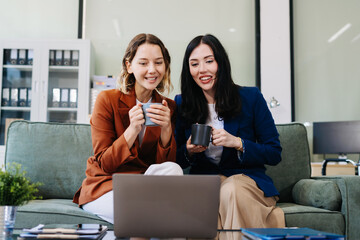 Female colleague caucasian descent holds a cup of coffee and talking discussion ideas and happily.