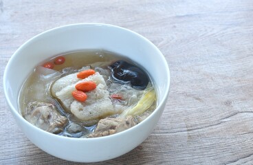 boiled bamboo mushroom with pork bone and black ear mushroom in clear Chinese herb soup on bowl