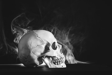 Human skull on a black background in smoke.