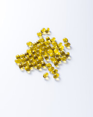 Yellow capsules with vitamins on a white background