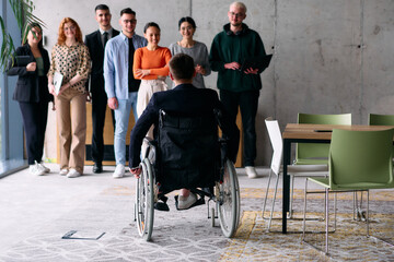 A diverse team of business professionals in a modern office stands alongside their director in a wheelchair, embodying inclusivity, collaboration, and leadership in the workplace
