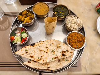Thali Mahlzeit Restaurant aus Gemüse- und Fleischcurries in kleinen Mettalschalen auf einem runden Tablett Jaipur in Indien
