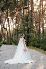 Obraz premium portrait of happy bride with bouquet in park