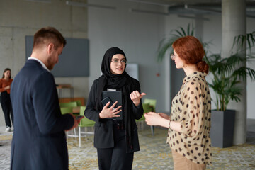 A business team engages in a lively discussion during a coffee break, exchanging challenges and sharing moments of laughter, fostering a positive and collaborative work environment