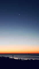 Aerial View of Calm Ocean with the Moon at Sunset Hour.