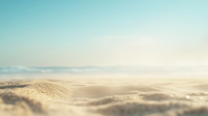 A close-up shot of beach sand with a blurred sea and sky background.