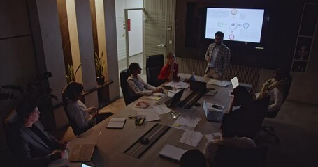 Multiracial people working late in a modern office. A diverse team collaborates on a project during a business meeting. - Powered by Adobe