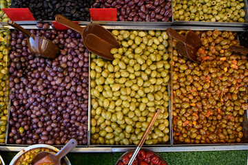 Overhead, high angle view of a variety of olives in bulk bins at an outdoor market in Jerusaelm, Israel.