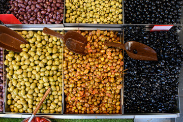 Overhead, high angle view of a variety of olives in bulk bins at an outdoor market in Jerusaelm,...