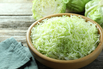 Fresh shredded cabbage on wooden table, closeup